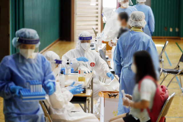 8일 오전 광주 북구의 한 초등학교에서 광주 북부보건소 역학 조사팀 직원들이 임시 선별진료소를 설치하고 학생들과 교직원들을 대상으로 전수조사를 하고 있다. 연합뉴스