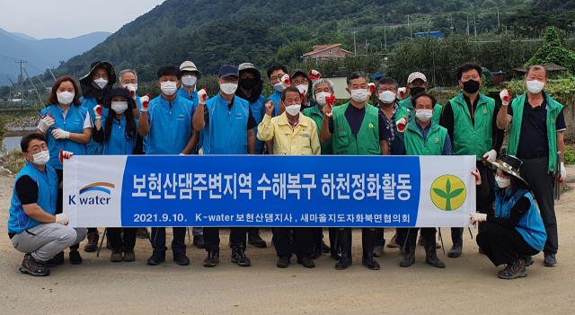 K-water 보현산댐지사 및 새마을지도자화북면협의회 회원들이 하천정화활동을 펼친 후 기념촬영을 하고 있다. K-water 보현산댐지사 제공