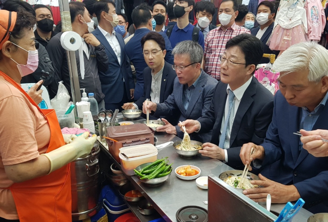 국민의힘 대권주자인 유승민 전 의원이 13일 대구 서문시장을 찾아 국수를 먹으며 상인과 얘기를 나누고 있다. 연합뉴스
