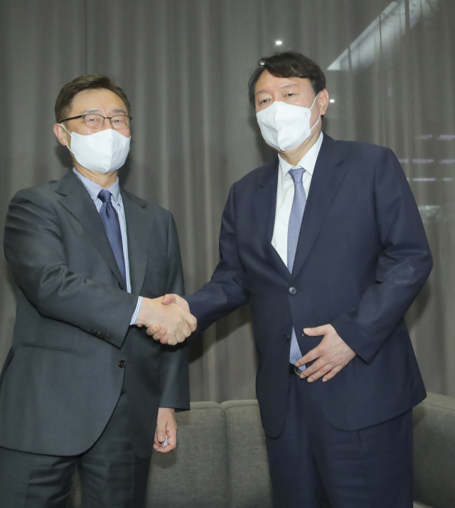 국민의힘 윤석열, 최재형 대선 경선 예비후보가 12일 서울 여의도 글래드 호텔에서 고발 사주 의혹의 정치공작 가능성 등에 대한 대처방안을 논의한 뒤 악수하고 있다 . 연합뉴스
