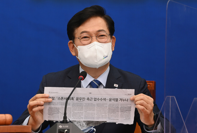 더불어민주당 송영길 대표가 13일 오전 국회에서 열린 최고위원회의에서 윤석열 전 검찰총장 부인과 측근에 대한 검찰 수사 기사를 들어보이며 발언하고 있다. 연합뉴스