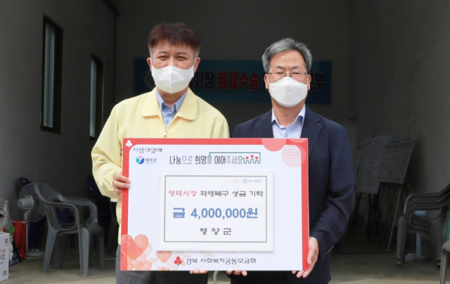 오도창 영양군수가 이희진 영덕군수에게 영양군청 공무원과 체육회에서 모금한 영덕상인돕기 성금을 전달하고 있다. 영양군 제공