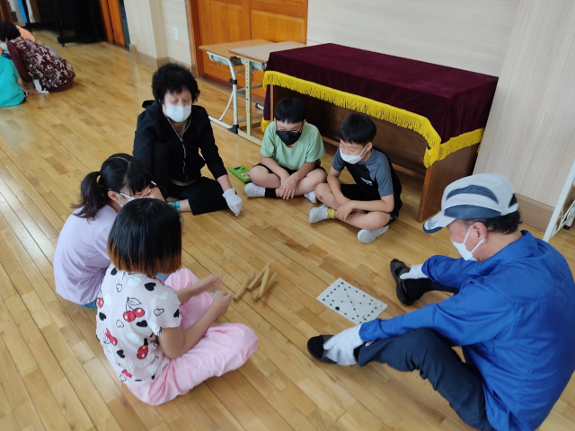 얼굴을 맞대다 보면 세대 간 이해와 소통의 실마리도 찾을 수 있다. 서대구초등학교 강당에서 이곳 학생들과 학교 인근의 어르신들이 어울려 윷놀이를 즐기는 모습. 대구시교육청 제공