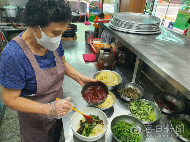 포항 보경사군립공원 산채비빔밥 골목의 진주식당 사장인 강금자(72) 씨가 포항초산채비빔밥 한그릇을 담아내고 있다. 강씨의 식당은 이 골목에서도 가장 오래된 터줏대감이다. 신동우 기자