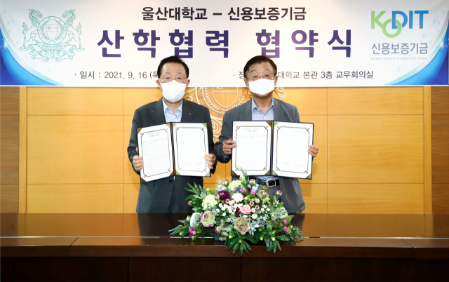 윤대희 신용보증기금 이사장(왼쪽)과 오연천 울산대학교 총장(오른쪽)이 16일 울산대학교에서 개최된 
