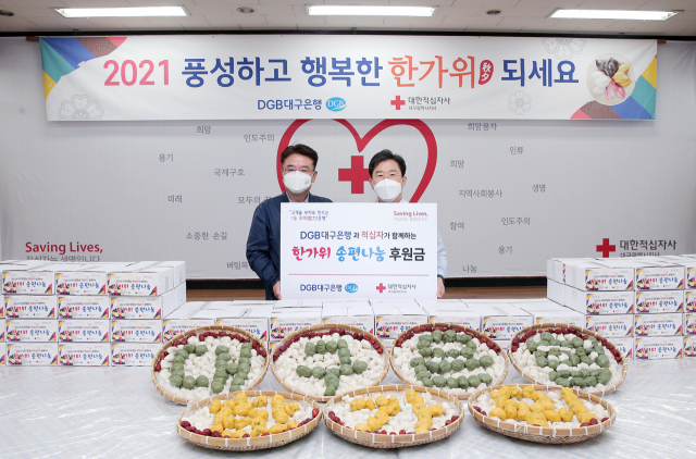 DGB대구은행 임직원들과 대학생 홍보대사, 자원봉사자들은 이달 15, 16 양일 간 지역 아동 및 취약계층을 위한 한가위 송편 및 치킨 나눔 행사를 가졌다. 왼쪽부터 서문선 DGB대구은행 부행장, 송준기 대한적십자사 대구지사 회장.