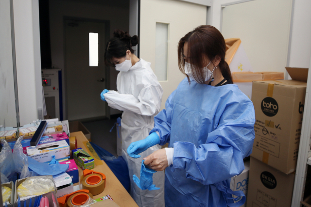 추석 명절 연휴 이틀째인 19일 오전 광주 서구 선별진료소 의료진이 방호복을 입고 있다. 연합뉴스