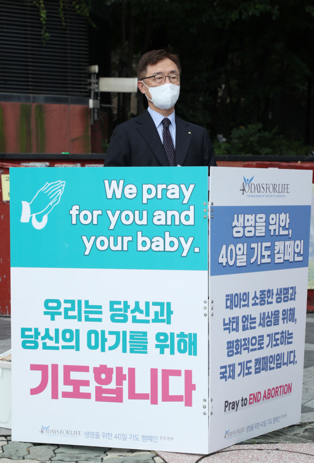 국민의힘 대권주자인 최재형 전 감사원장이 22일 서울 마포구 경의선숲길 인근에서 열린 태아생명보호를 위한 40일 기도캠페인에서 낙태 반대 릴레이 1인 시위를 하고 있다. 연합뉴스