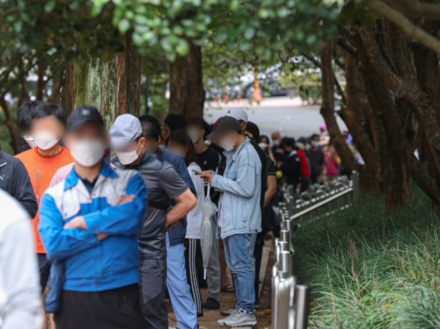 코로나19 신규 확진자가 3천 명을 돌파한 가운데, 지난 25일 오전 대구 두류야구장 임시 선별검사소를 찾은 많은 시민들이 코로나19 검사를 받기 위해 줄지어 기다리고 있다. 안성완 기자 asw0727@imaeil.com