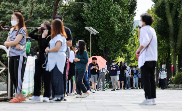추석 연휴 이동량의 증가로 인한 신종 코로나바이러스 감염증(코로나19) 확진자 급증하고 있는 27일 오전 서울 송파구 올림픽 공원 코로나19 임시 선별진료소에서 시민들이 검사를 받기 위해 줄지어 서 있다. 이날 보건당국이 발표한 코로나19 신규확진은 2천383명을 기록, 일요일 기준 최다 확진을 기록했다. 연합뉴스
