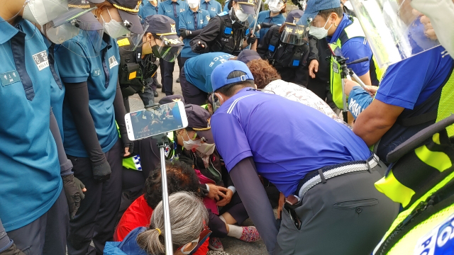 경찰이 사드 기지 차량 반입을 저지하고 있는 사드 반대 측 농성자를 설득을 하고 있다. 사드철회 소성리종합상황실 제공
