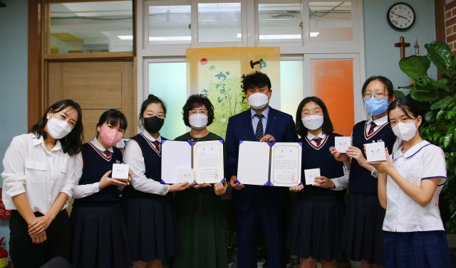 제14회 전국 학생 일본어 연극 발표대회에서 중학교 부문 대상을 받은 성명여중 학생들. 사진 왼쪽부터 조민재 지도교사, 안지원, 최보나 학생, 권순희 교감, 배익홍 교장, 성지윤, 변해나, 정아연 학생. 대구시교육청 제공