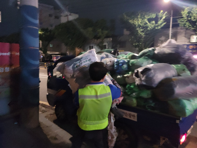 27일 오후 11시쯤 한 청소노동자가 100ℓ 종량제봉투를 옮기고 있다. 최혁규 기자