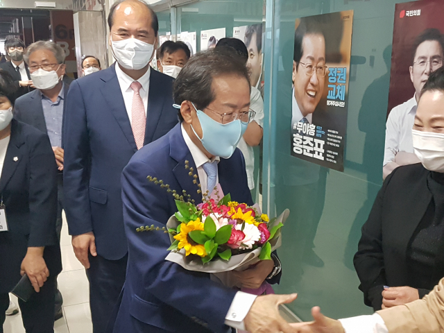 29일 오전 11시 40분쯤 홍준표 국민의 힘 대통령후보가 상주 문경 당협사무실에 도착해 당원으로부터 꽃다발을 받고 악수를 청하고 있다. 고도현 기자