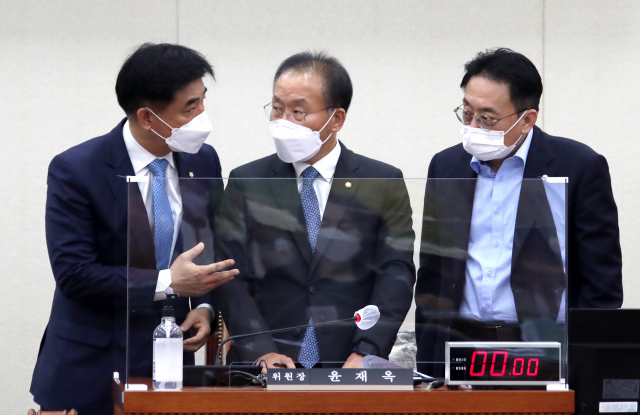 윤재옥 정무위원장(가운데)이 29일 국회에서 열린 정무위원회 전체회의에서 더불어민주당 김병욱 간사(왼쪽), 국민의힘 김희곤 간사와 국정감사 증인 채택 등과 관련해 논의하고 있다. 연합뉴스