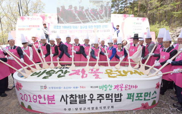 비슬산참꽃문화제에서 김문오 달성군수를 비롯한 기관단체장들이 총 2천19명분의 주먹비빔밥을 만들고 있다. 달성군 제공