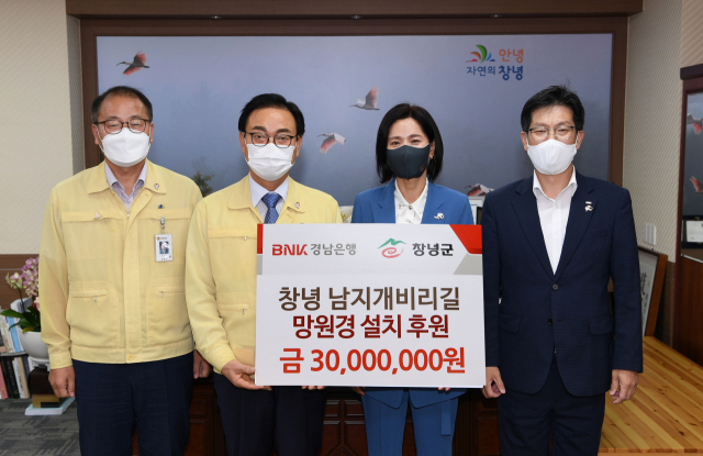 BNK경남은행 사랑나눔재단은 창녕 남지 개비리길에 망원경 설치비 3천만원을 기탁하고 기념촬영을 했다. 창녕군 제공