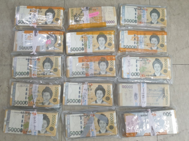 온라인에서 구매한 중고 김치 냉장고에서 발견된 출처를 알 수 없었던 현금 1억1천만원이 한 달 반 만에 주인을 찾았다. 제주 서부경찰서는 지난달 초 중고 김치냉장고에서 발견된 현금 1억1천만원의 주인이 서울에 살던 60대 여성 A씨로 확인됐다고 28일 밝혔다. 사진은 중고 김치냉장고 바닥에 붙어있던 1억1천만원. [제주서부경찰서 제공. 재판매 및 DB 금지] 연합뉴스