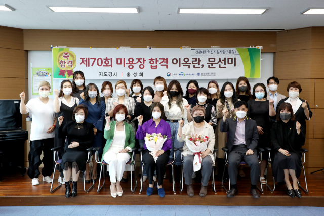 제70회 미용장 시험에 합격한 문선미, 이옥란 씨(앞줄 왼쪽 세번째부터)가 수강생들과 함께 기념촬영을 하고 있다. 영남이공대 제공