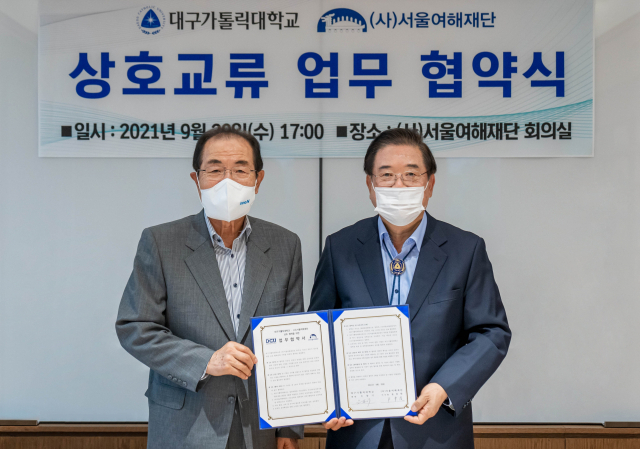 우동기 대구가톨릭대 총장과 윤동한 (사)서울여해재단 이사장이 이순신학과 설립을 위한 업무 협약서를 들어보이고 있다. 대구가톨릭대 제공