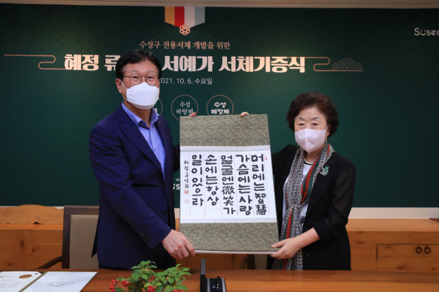 대구지역을 대표하는 류영희 서예가가 6일 수성혜정체 개발을 위해 수성구청을 방문해 판본체 1필을 김대권 구청장에게 전달했다. 수성구청 제공.