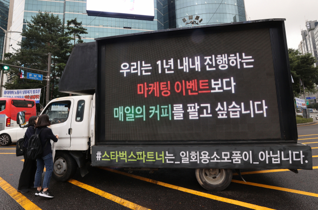 7일 오전 서울 강남구 강남역 인근 도로에 스타벅스 직원들의 처우개선을 요구하는 문구가 적힌 트럭이 정차해있다. 이번 트럭시위는 지난달 28일 실시된 스타벅스의 다회용 컵 무료 제공 이벤트가 계기가 된 것으로 보인다. 당시 스타벅스가 음료 주문 시 다회용 컵을 무료 제공하는 이벤트를 벌이자 매장에는 고객이 몰려 북새통이 됐다. 연합뉴스