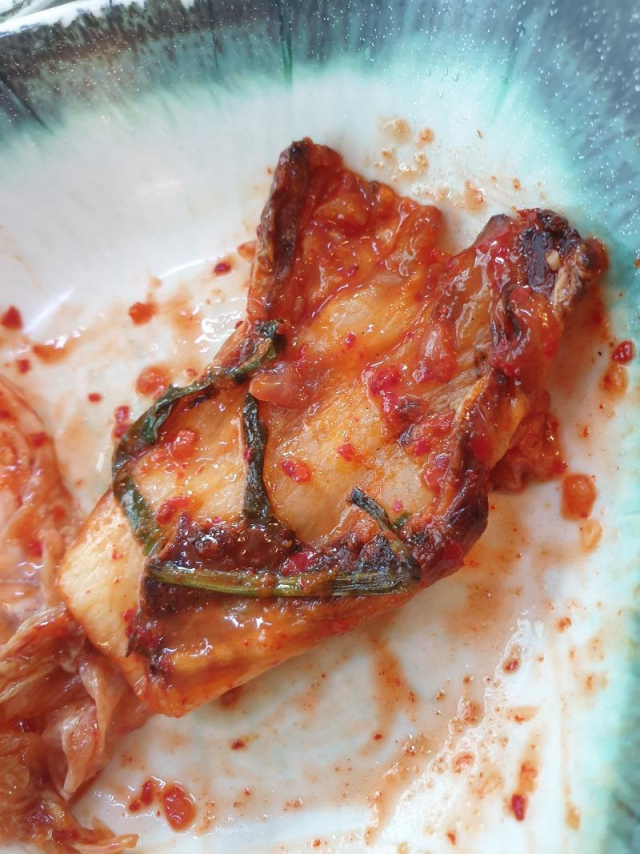 기본반찬으로 제공되는 생김치 안에서 발견된 불에 탄 김치사진.온라인커뮤니티 캡쳐