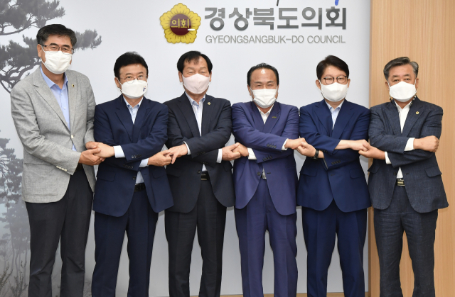 8일 열린 경북도의회 의장단·상임위원장 연석회의에 참석한 시장·도지사 등이 손을 맞잡고 기념촬영을 하고 있다. 왼쪽부터 도기욱 부의장, 이철우 도지사, 고우현 의장, 김영만 군위군수, 권영진 대구시장, 김희수 부의장. 경북도 제공
