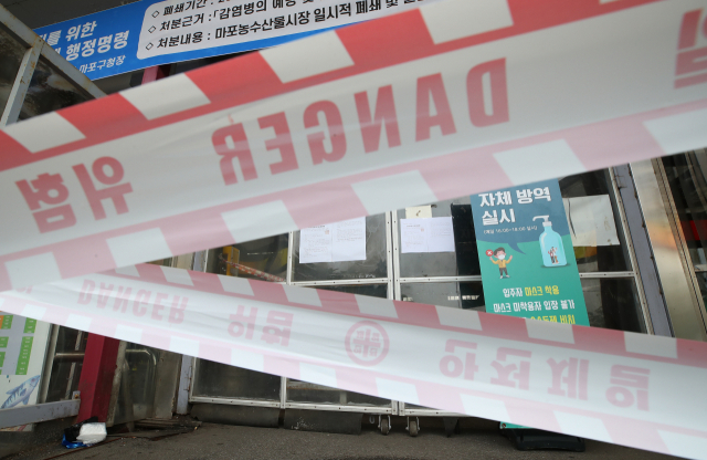 10일 오전 서울 마포농수산물시장 입구에 출입을 막는 테이프가 설치돼 있다. 마포구는 코로나19 집단감염이 발생한 마포농수산물시장에 대해 9일 폐쇄 행정명령을 내렸다. 연합뉴스