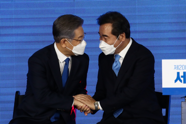 10일 오후 서울 송파구 올림픽공원 SK올림픽핸드볼경기장에서 열린 제20대 대통령선거 후보자 선출을 위한 서울 합동연설회에서 대선 후보로 확정된 이재명 경기도지사가 이낙연 후보와 손을 잡고 대화하고 있다. 연합뉴스