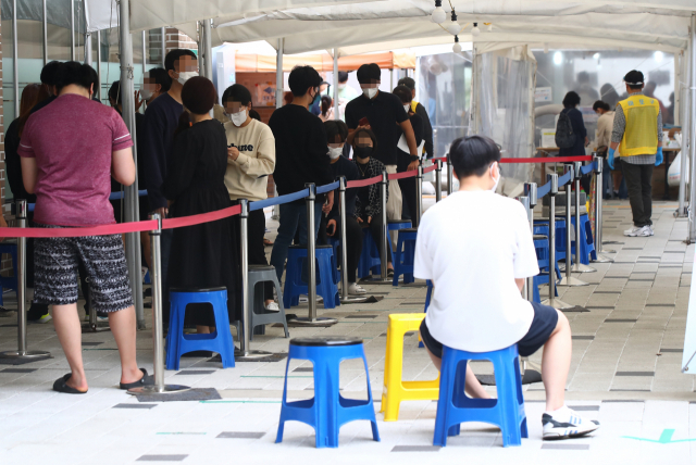 10일 오전 코로나19 집단감염으로 폐쇄된 서울 마포농수산물시장 인근에 있는 서울 마포구보건소 코로나19 선별진료소를 찾은 시민들이 검체 검사를 기다리고 있다. 이날 0시 기준 신규확진자 수는 주말 검사 건수 감소 영향으로 1천594명으로 집계됐다. 연합뉴스