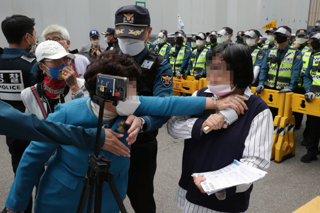 11일 오후 이낙연 후보 지지자들이 대선 후보 경선 무표효 처리 이의제기 관련해 서울 여의도 더불어민주당사 앞에서 기자회견을 하는 가운데 이낙연 후보 지지자가 유튜브 방송을 하고 있는 이재명 후보 지지자(오른쪽)를 저지하고 있다. 연합뉴스