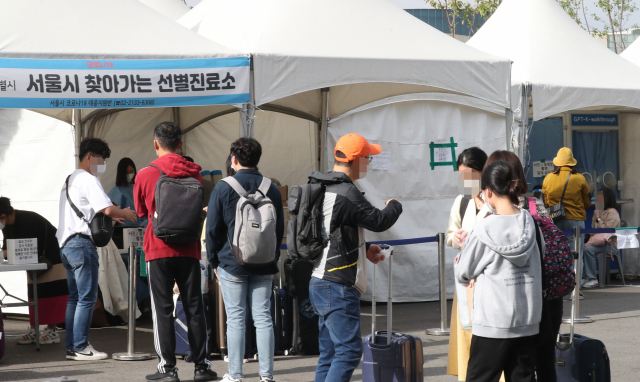 11일 오후 서울시 강서구 김포공항에 마련된 코로나19 임시선별진료소에서 여행을 다녀온 관광객들이 코로나 검사를 받기 위해 줄을 서 있다. 연합뉴스