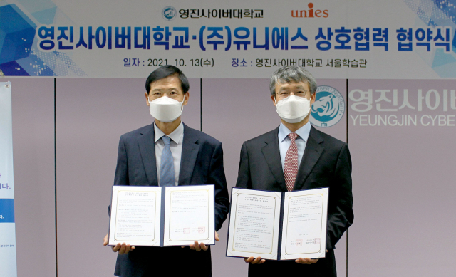 배상훈 (주)유니에스 본부장(왼쪽)과 류용희 영진사이버대 부총장이 협약서를 들어보이고 있다. 영진사이버대 제공