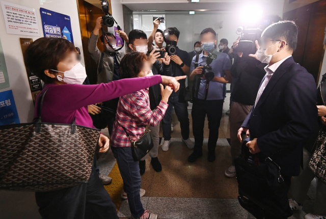 화천대유 심종진 공동대표가 15일 경기도 성남시청에서 열린 대장지구 이주자택지 보상관련 협의에 참석한 뒤 대장동 원주민들의 항의를 받고 있다. 연합뉴스