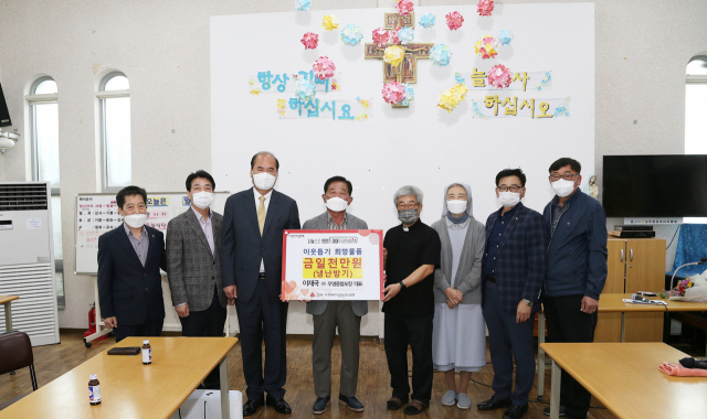 이재국 ㈜우영종합포장 대표(왼쪽에서 네 번째)가 15일 상주 계림성당 무료급식소를 찾아 냉·난방기 교체 비용 1천만원을 기탁했다. 상주시 제공