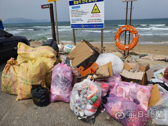 포항시 북구 흥해읍 용한리 해변 안내 표지판 밑으로 캠핑족이 두고 간 쓰레기가 가득 쌓여 있다. 신동우 기자