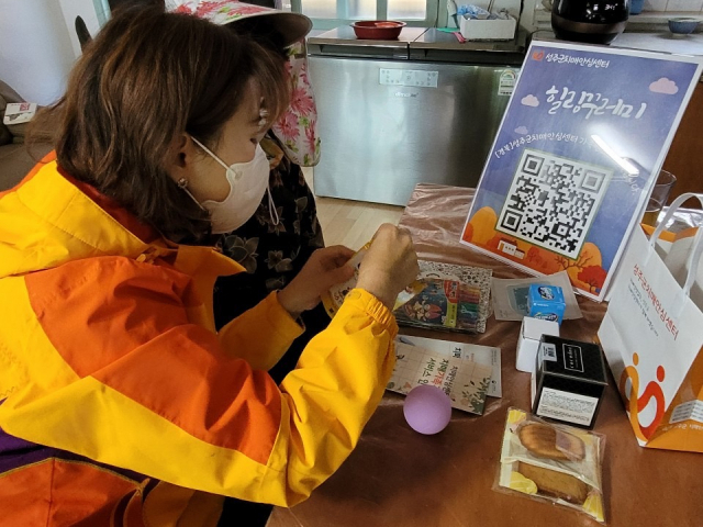 성주군 치매안심센터 관계자가 치매환자 돌봄에 지친 가족에게 힐링꾸러미를 전달하고 있다. 성주군 제공