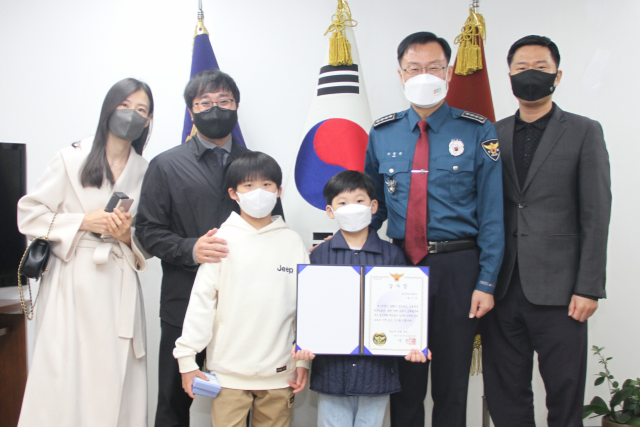지난 12일 대구 중구에서 실종된 80대 치매노인을 찾는데 기여한 박시우(8·왼쪽에서 네번째) 군과 가족들. 대구 중부경찰서 제공