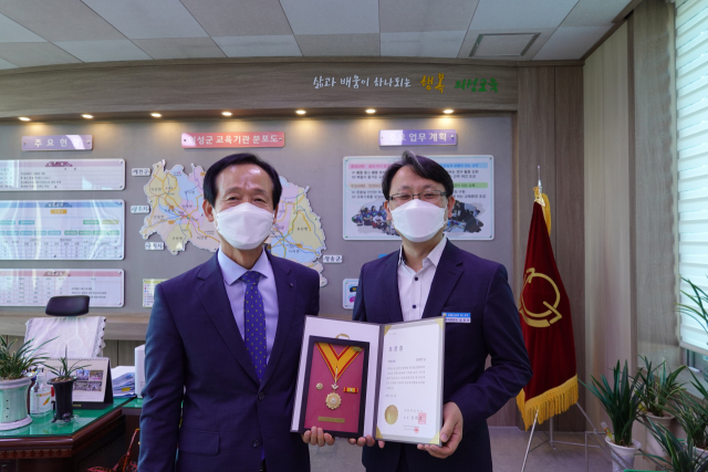 경북 의성교육지원청 김경민(오른쪽) 재정지원담당이 대한적십자사로부터 명예대장을 수상하고 이정희(왼쪽) 의성교육장과 기념 사진을 촬영하고 있다. 의성교육지원청 제공