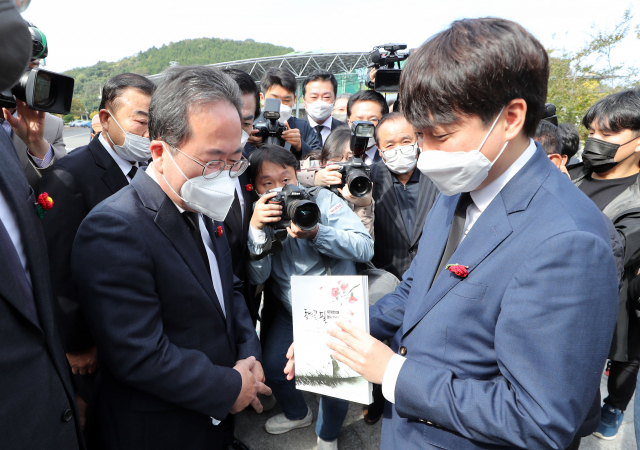 국민의힘 이준석 대표(오른쪽)가 21일 오전 전남 순천시 팔마체육관에 있는 여순항쟁위령탑을 찾아 참배한뒤 허석 순천시장으로부터 여순사건을 주제로 제작한 교육용 책자를 받고 있다. 연합뉴스