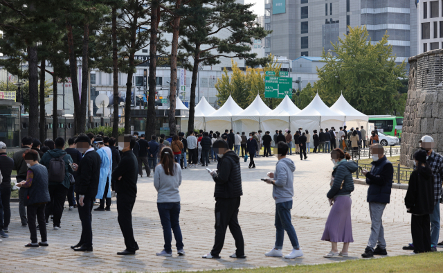 22일 오후 서울 종로구 흥인지문 앞에 설치된 찾아가는 임시선별진료소에서 인근 시장 상인과 시민 등이 코로나19 선별검사를 받기 위해 순서를 기다리고 있다. 서울시는 종로구 소재 시장에서 발생한 신종 코로나바이러스 감염증 집단감염 확진자가 총 152명으로 늘었다고 이날 밝혔다. 시는 첫 감염자가 나온 뒤 2주 넘게 확산이 이어지자 전날 시장 내 모든 점포 운영자와 종사자에게 코로나19 검사를 받도록 행정명령을 내렸다. 연합뉴스