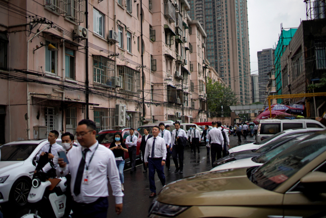 중국 상하이의 주거지역에서 지난 15일 부동산 중개인들이 무리를 지어 걸어가고 있다. 연합뉴스