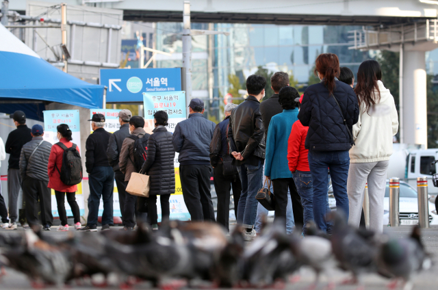 코로나19 신규 확진자 수가 1천423명을 기록한 24일 오전 서울 중구 서울역 코로나19 임시 선별검사소에서 시민들이 검사를 기다리고 있다. 연합뉴스
