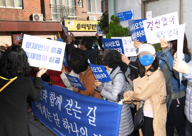 24일 오후 더불어민주당 대선 후보인 이재명 경기도지사와 이낙연 전 대표의 회동 장소인 서울 종로구 안국동 한 찻집 인근에 양측 지지자들이 손팻말을 들고 있다. 연합뉴스