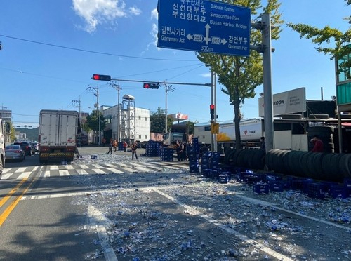 25일 오전 11시 57분쯤 부산 남구 감만동 신선로를 달리던 25t 화물차에서 맥주병 수백 개가 바닥에 쏟아져 한때 주변 교통이 마비됐다. 연합뉴스