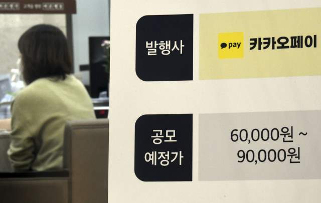카카오페이 공모주 청약일인 25일 서울 영등포구 여의도 한국투자증권 여의도본점 영업장에 설치된 카카오페이 청약 입간판 너머로 고객들이 상담을 받고 있다. 연합뉴스