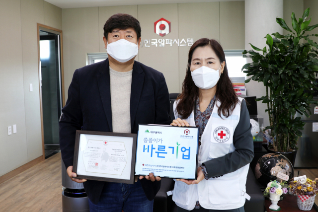 박선영 (오른쪽)대한적십자사 대구광역시지사 사무처장이 김재용 (주)한국알파시스템 대표에게 명패전달식을 하고있다.
