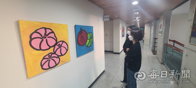 경북 경산시보건소 직원들이 2층 복도에 전시된 정태경 화백의 작품을 감상하고 있다. 경산시보건소 제공