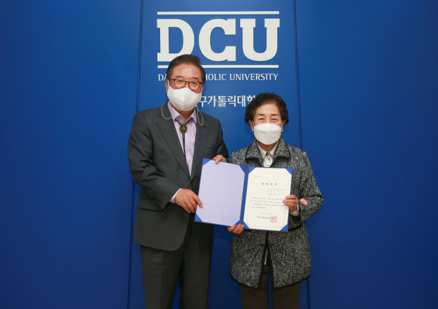 대구가톨릭대 우동기 총장(왼쪽)이 26일 효성캠퍼스 본관에서 만학도 김봉순 씨에게 총장특별장학금 장학증서를 수여했다.
